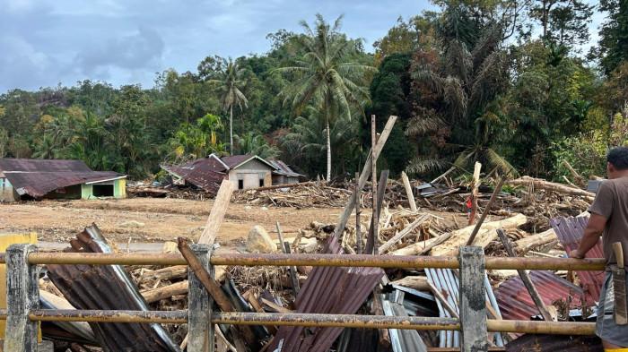 KAYO GELONDONGAN - Potret rumah warga yang dipenuhi gelondongan kayu pascabencana longsor dan banjir bandang di Tapanuli Tengah, Kamis (4/12/2025). Batang-batang kayu ini terbawa arus dari perbukitan dan menimpa permukiman.
