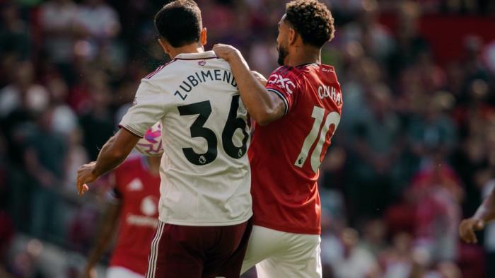 BEREBUT - Pemain Manchester United, Matheus Cunha (merah0 berebut bola dengan pemain Arsenal dalam laga Liga Inggris 2025-2026 pekan pertama di Old Trafford.