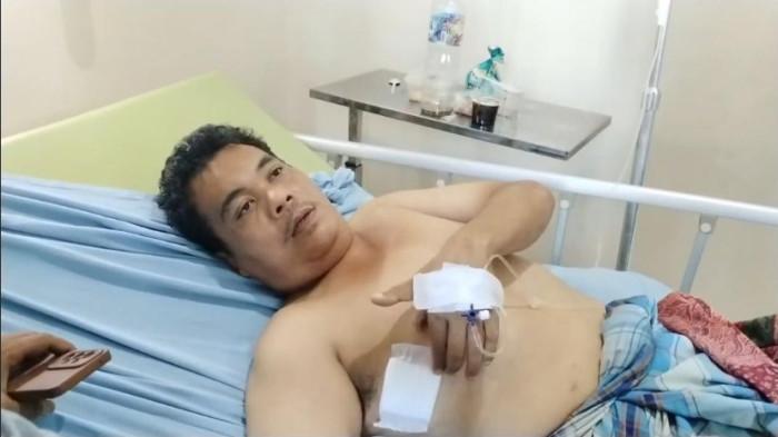 KORBAN PERAMPOKAN - Guntur Sugoro (41) masih terbaring di atas ranjang rumah sakit RS Pirngadi Medan, Selasa (19/5/2026). Satpam salah satu dapur makan bergizi gratis (MBG) jadi korban perampokan, hingga punggung kena tembak.