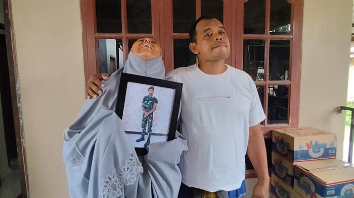 Ibu Pratu Farkhan Syauqi Marpaung, Marsinah Wati Silalahi terkulai memeluk bingkai foto anaknya di rumah duka, Dusun IV, Desa Hessa Air Genting, Air Batu, Kabupaten Asahan, Jumat (2/1/2026). Setelah dikabarkan meninggal dunia dalam tugas di perbatasan Indonesia - Papua Nugini.
