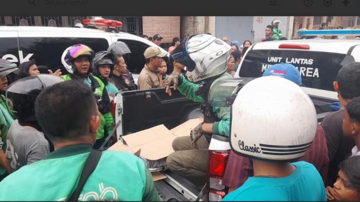 OJOL TERSAMBAR KERETA - Jenazah pengemudi Ojol yang tersambar kereta api di perbatasan Kecamatan Medan Denai dan Kecamatan Medan tembung dievakuasi ke RS Bhayangkara, Senin (20/4/2026). Ojol bernama Rajali ini, tersambar kereta api saat mengantar penumpang.