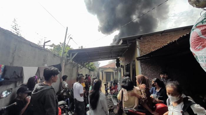 KEBAKARAN PABRIK MAINAN - Warga sekitar pabrik mainan berbahan plastik, di Kecamatan Medan Johor, Kota Medan, kembali mengangkat barang berharga karena api kembali membesar, Minggu (21/6/2026). Kebakaran hebat yang menghanguskan pabrik mainan ini, terjadi sejak Sabtu (20/6/2026) malam tadi.