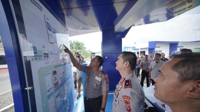 Kapolda Sumatera Utara, Irjen Pol Whisnu Hermawan Februanto, S.I.K., M.H.,  (kiri) saat melihat panduan layanan pengisian Kendaraan Listrik di SPKLU PLN Presisi.