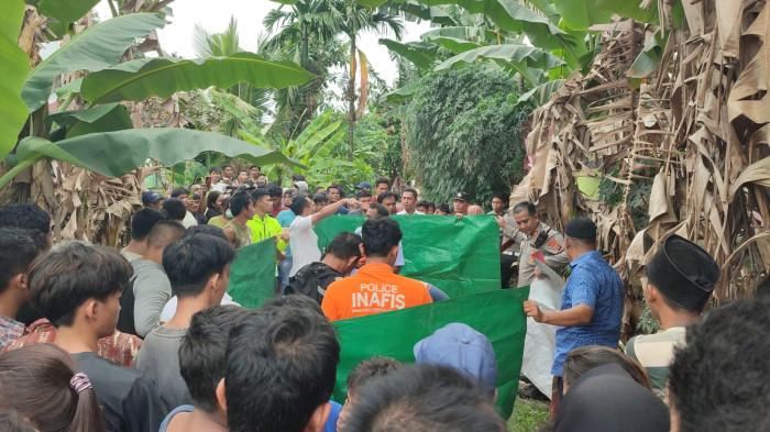 MAYAT DALAM BOX - Tim Inafis Polrestabes Medan, melakukan pengecekan awal kondisi jenazah wanita yang ditemukan dibuang di perladangan pisang, di Jalan Menteng 7, Gang Seroja 3, Kecamatan Medan Denai, Kota Medan, Selasa (10/3/2026). Sebelumnya, warga sempat melihat dua pria membuang box ke ladang di pinggir aliran Sungai Deli itu.