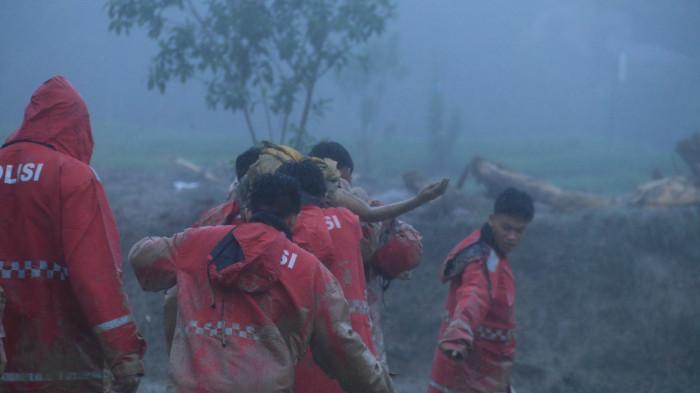EVAKUASI - Petugas mengevakuasi warga yang menjadi korban banjir di Humbahas, Sumut