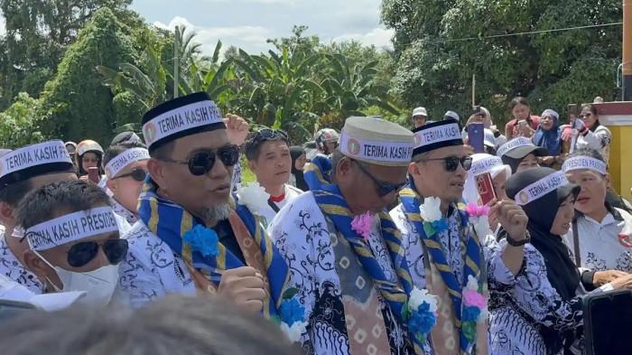 GURU DI LUTRA - Rasnal dan Abdul Muis saat tiba di perbatasan Luwu - Luwu Utara, Selasa (18/11/2025). Ribuan guru yang menyambut Rasnal dan Abdul Musi kompak kenakan ikat kepala yang bertuliskan 'terimakasih presiden prabowo'.  