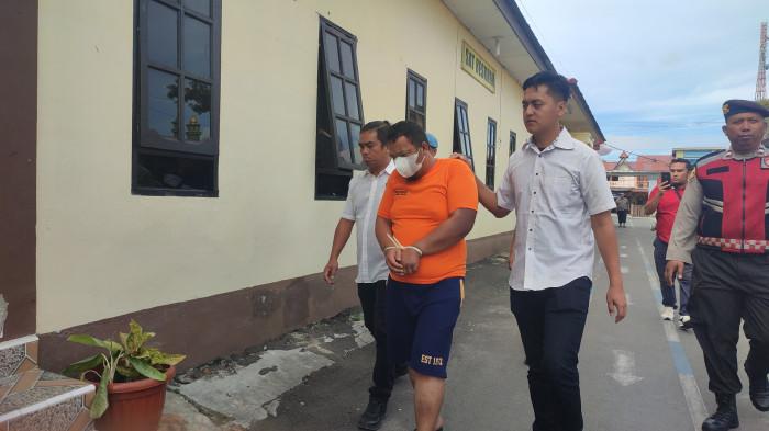 Radinal Kudadiri, pelaku begal payudara saat digiring menuju ruang tahanan Polres Dairi usai menjalani konferensi pers di Mapolres Dairi, Rabu (27/8/2025).  