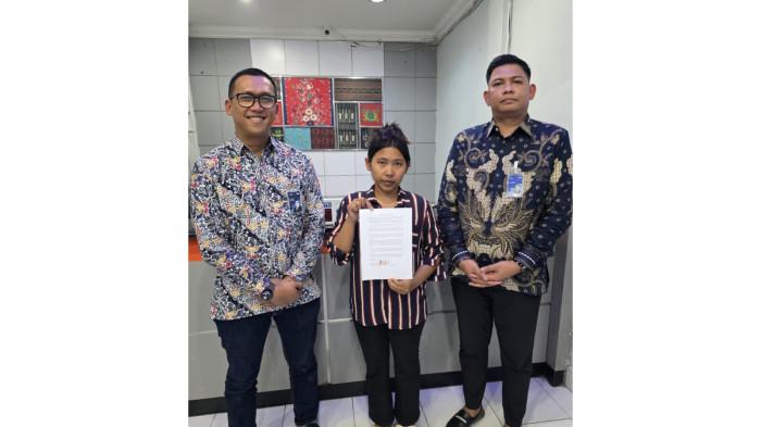 SALDO NASABAH RAIB - Pimpinan Cabang (Pinca) bank BRI Cabang Kabanjahe Donny Cahyono (kiri), bersama dengan Mayesti br Perangin-Angin (tengah), nasabah yang sempat kehilangan saldo di bank BRI Unit Laubaleng, menunjukkan surat hasil penyelesaian masalah, di Kantor BRI Unit Laubaleng, Rabu (12/11/2025).