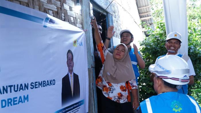 Senyum bahagia bu Atik saat menyalakan langsung listrik di rumahnya.