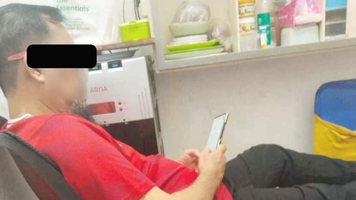 Seorang tahanan di Rutan Tanjung Gusta Medan diduga mantan Kadis Kominfo sedang bermain handphone.