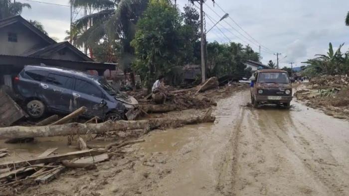BANJIR BANDANG - Seorang warga sedang melihat mobil yang melintas usai banjir bandang di Huta Godang, Batangtoru, Tapsel, Kamis (27/11/2025).