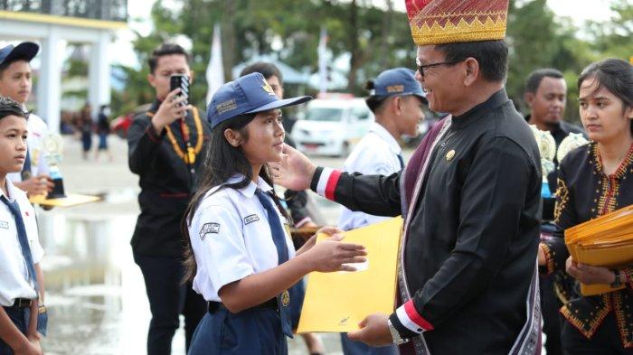 HARI PENDIDIKAN NASIONAL: Wakil Bupati Pakpak Bharat, H Mutsyuhito Solin, Dr, M.Pd atas nama Bupati Franc Bernhard Tumanggor memberikan penghargaan kepada para pelajar berprestasi se Kabupaten Pakpak Bharat dalam upacara peringatan Hari Pendidikan Nasional tahun 2025 tingkat Kabupaten Pakpak Bharat di Lapangan Napa Sengkut, Salak, Jumat (2/5/2025). (Diskominfo Pakpak Bharat)
