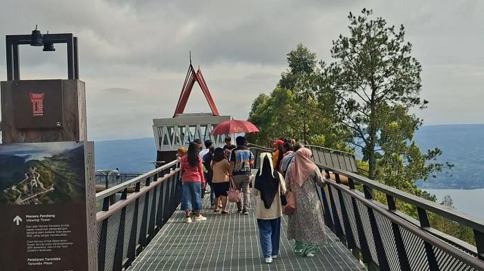 Suasana destinasi wisata di Samosir saat liburan. Waterfront City Pangururan dan Menara Pandang Tele merupakan destinasi wisata yang berada di Samosir.