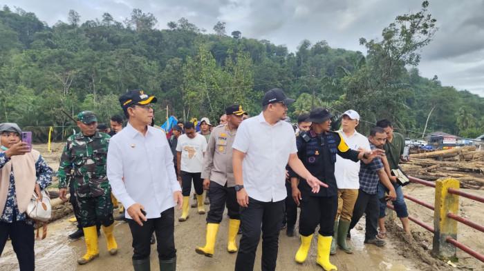 TINJAU BANJIR - Gubernur Sumut Bobby Nasution dan Bupati Tapsel Gus Irawan saat meninjau banjir bandang di Garoga, Batangtoru, Jumat (19/12/2025). Pemerintah akan membangun rumah untuk hunian tetap bagi para pengungsi. 