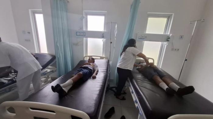 KERACUNAN MBG - Tim medis saat mengevakuasi siswa SMP Negeri 1 Laguboti ke rumah sakit karena diduga keracunan MBG, Rabu (15/10/2025). DPRD Sumut akan panggil pihak SPPG dan MBG