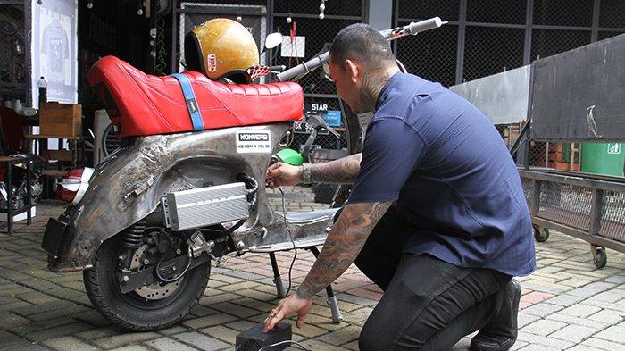 Siarkhansyah Singarimbun mengisi daya Vespa lawas miliknya yang telah diubah menjadi motor listri di Medan, Sumatera Utara, Jumat (30/12). Pemerintah berkomitmen mempercepat program konversi kendaraan bermotor BBM menjadi kendaraan bermotor listrik karena berdasarkan data Kementerian ESDM, dampak mengkonversi 6 juta motor BBM ke listrik akan mampu mengurangi BBM 12,8 juta barel/tahun, penurunan emisi CO2 sebesar 3,9 Juta Ton CO2, dan peningkatan konsumsi listrik sebesar 2,4 TWh/tahun.