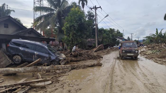 BANJIR BANDANG - Seorang warga sedang melihat mobil yang melintas usai banjir bandang di Huta Godang, Batangtoru, Tapsel, Kamis (27/11/2025).