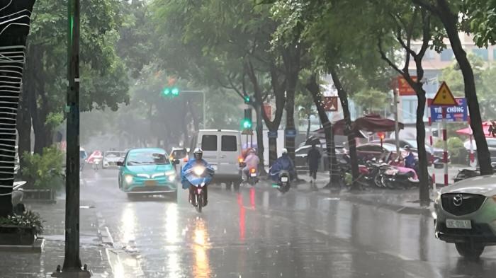 HUJAN SIANG- Ilustrasi sebuah kawasan perkotaan yang dilanda hujan siang hari. Tampak pengendara motor harus menggunakan mantel ketika melintas di jalan yang basah.