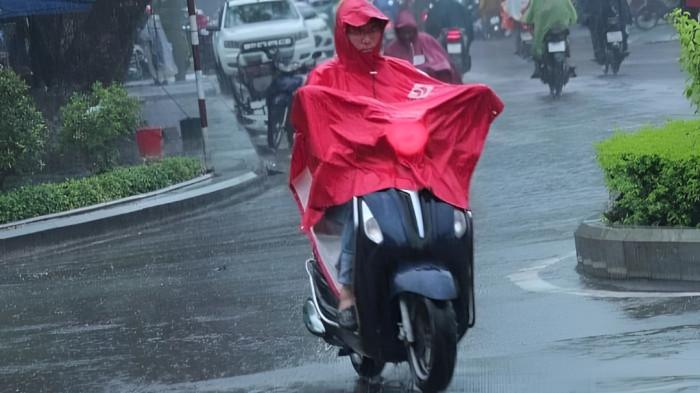 HUJAN LEBAT- Seorang pengendara motor tampak menggunakan jas hujan saat menembus hujan lebat yang melanda wilayah tempat tinggalnya.