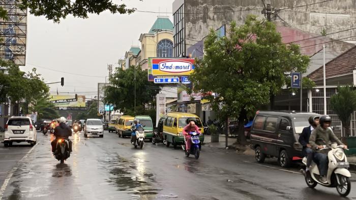 JALANAN BASAH- Kondisi jalan basah setelah diguyur hujan yang terjadi pada siang jelang sore hari. Tampak beberapa pengendara motor menggunakan mantel hujan.