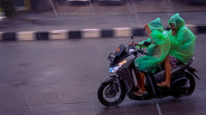 MENEMBUS HUJAN- Pengendara motor berusaha menembus hujan yang mulai lebat turun.