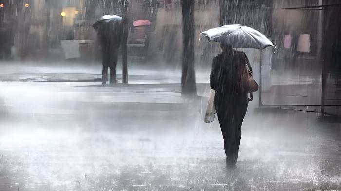 HUJAN LEBAT- Ilustrasi hujan deras yang melanda sebuah kawasan. Pejalan kaki terlihat menggunakan payung saat beraktivitas di luar rumah.