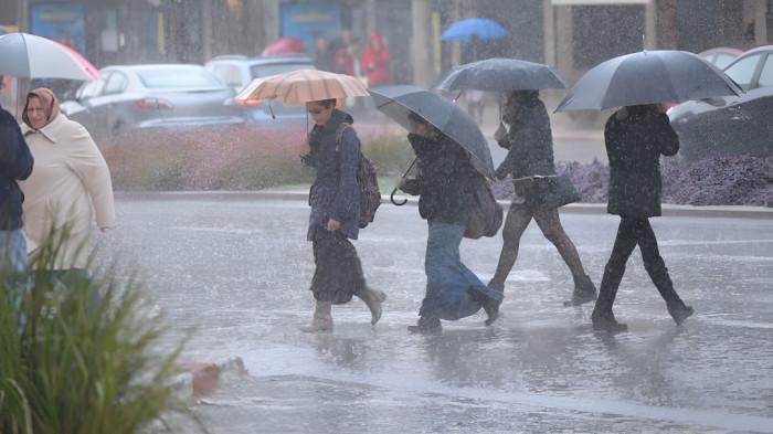 HUJAN SEDANG- Ilustrasi sebuah kawasan yang sedang dilanda hujan sedang, dimana masyarakatnya tampak beraktivitas membawa payung untuk menghindari guyuran hujan.