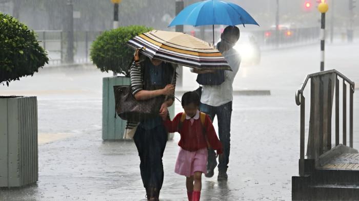 MENEMBUS HUJAN- Pengguna jalan di sebuah perkotaan tampak menembus hujan lebat yang mengguyur wilayah mereka.
