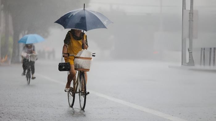 HUJAN SIANG- Ilustrasi hujan siang hari di sebuah kawasan perkotaan.