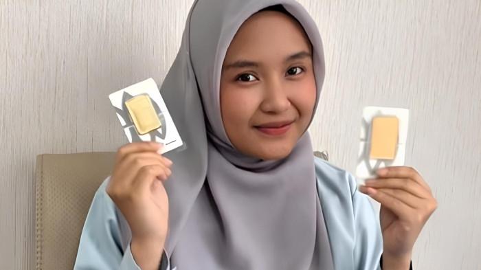 PECAH REKOR- Seorang pegawai PT Antam Indonesia saat memperlihatkan emas batangan yang harganya terus melonjak. Saat ini harga emas Antam pecah rekor di angka tertinggi yakni