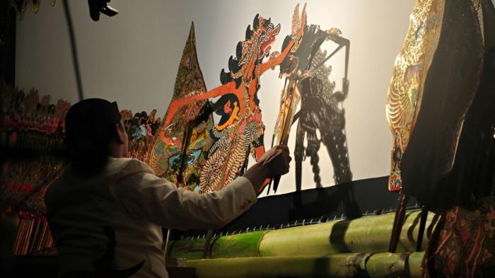 DALANG BERAKSI- Ilustrasi seorang dalang tengah beraksi memainkan wayang kulit yang merupakan bagian dari tradisi masyarakat Jawa. Hingga kini, budaya wayang kulit masih terjaga.