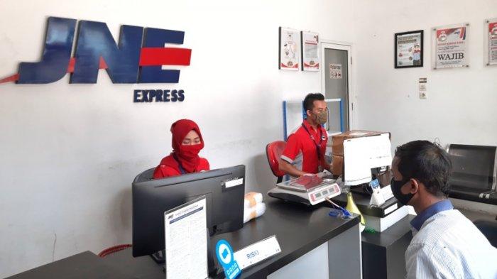 KARYAWAN JNE saat melayani konsumen untuk pengiriman barang di Kantor JNE, Medan.
