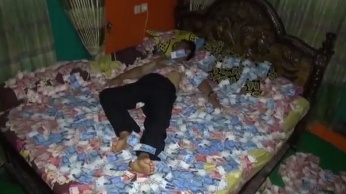 Viral, Video Lurah Hamburkan Uang dan Tidur di Atasnya