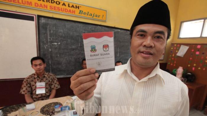 Mantan Bupati Garut Aceng Fikri memperlihatkan surat suara sebelum melakukan pencoblosan dalam pelaksanaan Pemilihan Bupati dan Wakil Bupati (Pilbup) Garut 2013 di TPS 20, Kampung Copong, Desa Sukamantri, Kecamatan Garut Kota, Kabupaten Garut, Minggu (8/9). Hasil real count sementara Pibup Garut 2013 yang diselenggarakan KPUD Kabupaten Garut hingga pukul 17.20 WIB, dari 10 pasang calon yang bertarung menuju Garut 1 dan 2 periode 2013-2018, menunjukkan pasangan nomor 8 Rudy Gunawan-Helmi Budiman unggul di peringkat pertama dengan 24,31 persen suara, disusul peringkat kedua pasangan nomor 5 Agus Hamdani-Abdusy Syakur dengan 22.86 persen suara, dan peringkat ketiga pasangan nomor 4 Memo Hermawan-Ade Ginanjar dengan 17,93 persen suara.