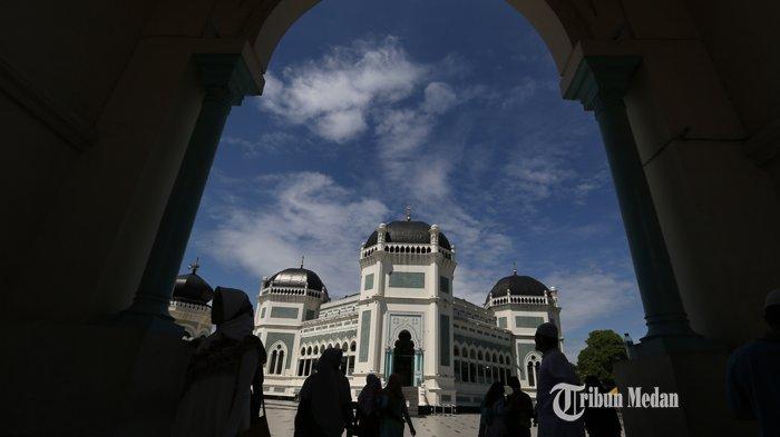 Wisatawan foto bersama dengan latar belakang bangunan bersejarah Masjid Raya Al-Mashun, Medan, Sumatera Utara, Selasa (20/8/2019).