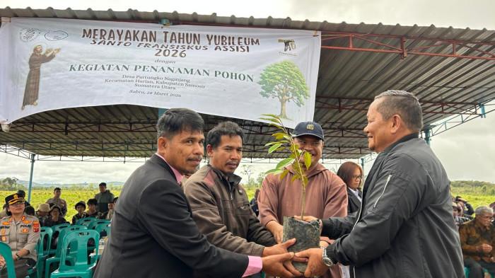 Ketua DPD PDI Perjuangan Sumatera Utara, Rapidin Simbolon, menerima bibit pohon dari Pastor Walden Sitanggang OFM Cap dalam kegiatan penanaman pohon di Desa Partungko Naginjang, Kecamatan Harian, Kabupaten Samosir, Sabtu (28/3/2026), sebagai simbol dimulainya upaya pemulihan hutan di kawasan Danau Toba.