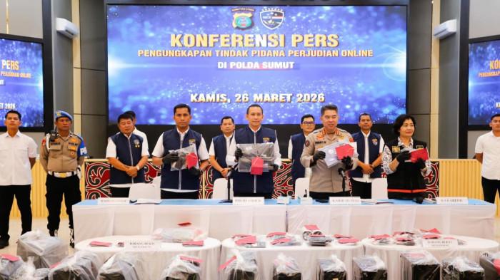 Direktur Reserse Siber Polda Sumatera Utara Kombes Pol Bayu Wicaksono (tengah) didampingi Kabid Humas Kombes Pol Ferry Walintukan (kiri) menunjukkan barang bukti perangkat elektronik saat konferensi pers pengungkapan kasus judi online di Aula Tribrata Polda Sumut, Medan, Kamis (26/3/2026). Polisi mengamankan 19 tersangka serta menyita puluhan perangkat dan sejumlah rekening yang diduga terkait jaringan judi online dengan omzet miliaran rupiah.