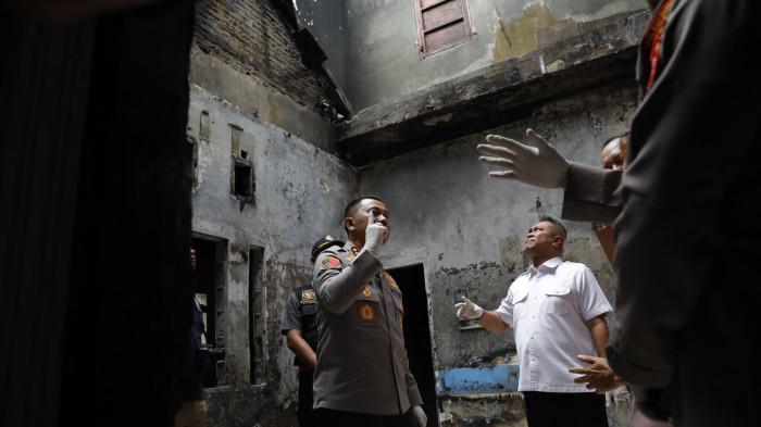 Kapolrestabes berdiskusi dengan korban, Hakim YM Khamozaro Waruwu, sambil meninjau ruang kamar utama yang terbakar, Rabu (5/11/2025). Calvijn memimpin Petugas memeriksa ruangan demi ruangan rumah bertingkat yang berdempetan dengan rumah tetangga sebagai bagian dari penyelidikan mendalam.