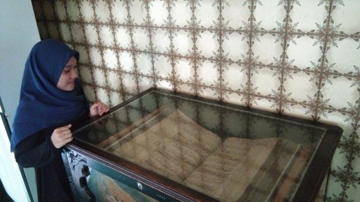 Satu di antara wisatawan melihat Al Quran tertua di Kota Medan yang terletak di dalam Masjid Raya Al Mashun yang terletak di Jalan Sisingamangaraja Nomor 61, Kelurahan Mesjid, Kecamatan Medan Kota, Kota Medan, Rabu (31/7/2019). 