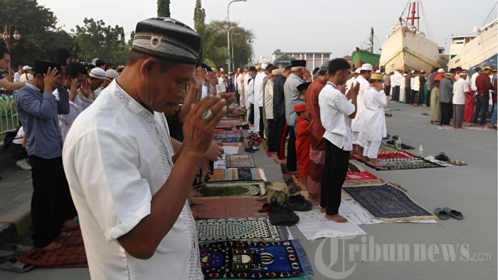 Umat muslim melaksanakan sholat Idul Fitri di kawasan Pelabuhan Sunda Kelapa, Jakarta, Jumat (15/6/2018). Sesuai ketetepan pemerintah 1 Syawal 1439 Hijriyah jatuh pada hari ini. Meski salat di kawasan galangan kapal laut, namun jamaah tetap khusyuk menjalankannya. TRIBUNNEWS/HERUDIN