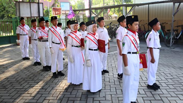 UPACARA- Sejumlah siswa yang bertugas dalam kegiatan upacara tampak bersiap sebelum memasuki lapangan upacara.
