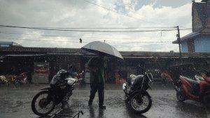 CUACA-EKSTREM-Seorang-warga-berjalan-di-tengah-guyuran.jpg