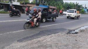 Pengendara-sepeda-motor-melintas-di-dekat-lubang-maut-yang-sudah-diaspal-di-Jalinsum.jpg