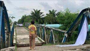 Seorang-anak-terlihat-berjalan-di-atas-jembatan-yang-roboh_Desa-Bandar-Setia_.jpg