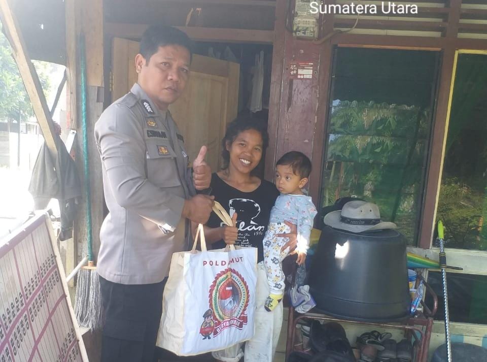 Bhabinkamtibmas-Polsek-Bripka-E-Siahaan-menyerahkan-paket-sembako-Bantuan-Polda-Sumatera-Utara.jpg