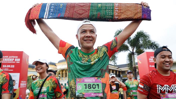 Gubernur-Jawa-Tengah-Ganjar-Pranowo-tersenyum-lebar-sembari-mengangkat-kain-ulos.jpg