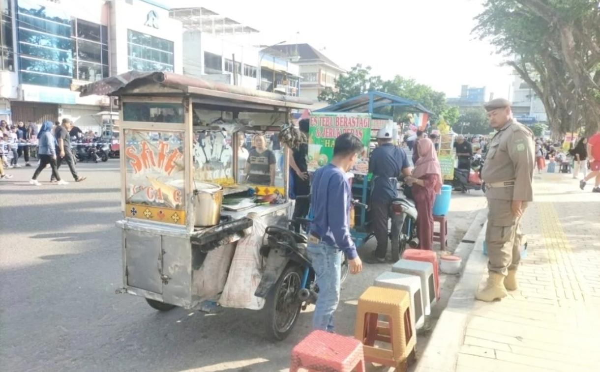 Pedagang-Kaki-Lima-jajakan-ban-motor-dengan-payung.jpg