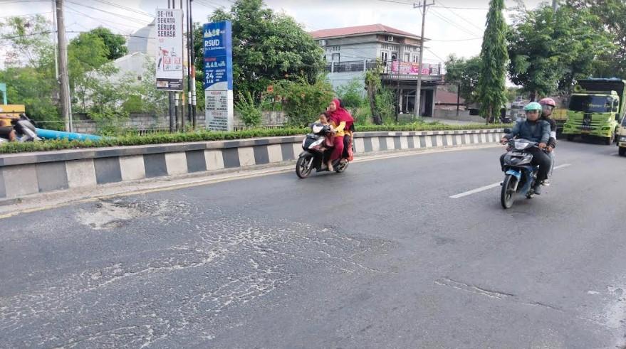Pengendara-sepeda-motor-di-Jalinsum-kawasan-Lubuk-Pakam-mendekati-lubang.jpg