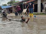 Aksi-mandi-dan-cuci-motor-di-kubangan-lumpur-warga-di-Jalan-Penghubung-Desa-Silo-Baru_.jpg