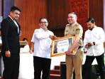 Bupati-Pakpak-Bharat-Franc-Bernhard-Tumanggor-menerima-penghargaan-UHC.jpg